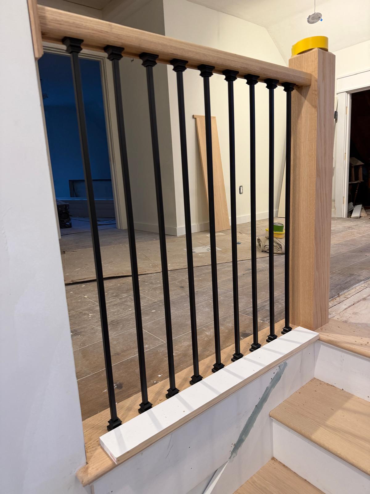 Oak handrail detail with black iron spindles