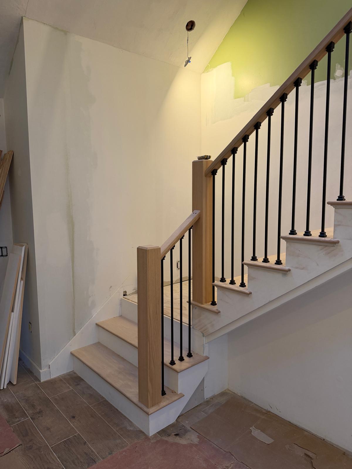 Staircase with wood newel posts and iron balusters